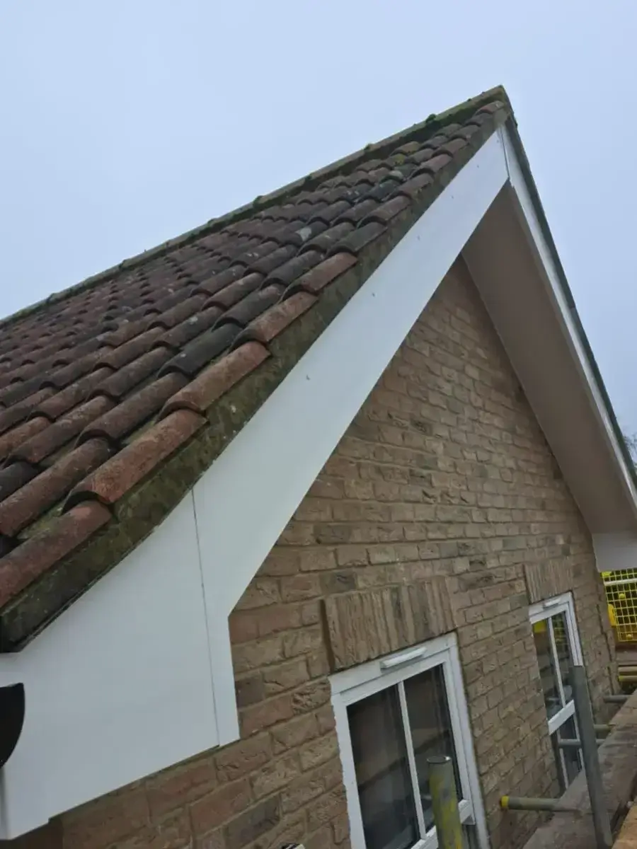 Crisp white uPVC replacement bargeboards and clean box end detailing on a domestic brick home gable by Norfolk Exterior Solutions